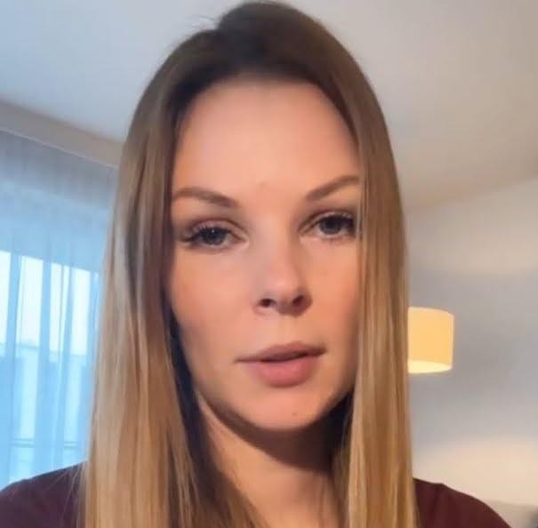 Małgorzata Tomaszewska podczas prowadzenia programu telewizyjnego, ukazana w dynamicznej pozie.