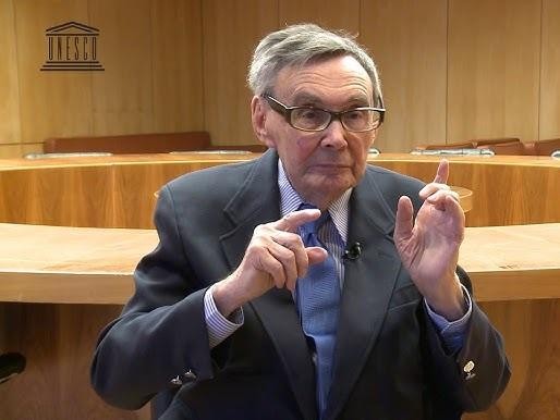 Marian Turski wygłaszający przemówienie, z intensywnym i zdeterminowanym wyrazem twarzy, podczas ważnego wydarzenia upamiętniającego.