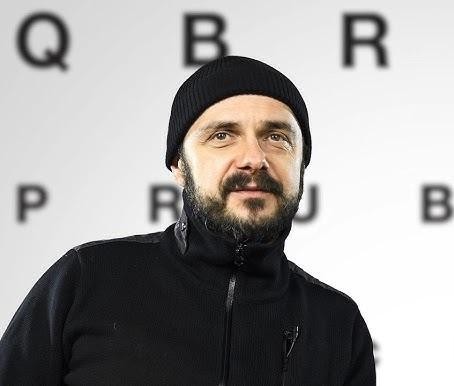 Arkadiusz Jakubik jako wokalista zespołu Dr Misio podczas energetycznego występu na scenie.