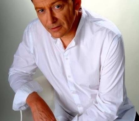 Jacek Borkowski z żoną Jolantą, uśmiechnięci, w ciepłym, domowym otoczeniu, symbolizujący ich wspólne życie i miłość.
