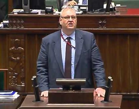 Bogdan Święczkowski w dynamicznej pozie, symbolizującej jego twardy styl zarządzania, z subtelnym nawiązaniem do przydomka 
