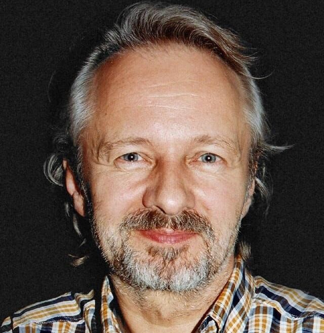 Krzysztof Stroiński w scenie filmowej/telewizyjnej, ukazującej jego intensywną grę aktorską i emocjonalne zaangażowanie.
