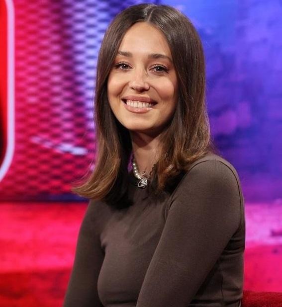 Dynamiczne ujęcie Izabelli Krzan, prezenterki telewizyjnej, w profesjonalnym stroju, uśmiechniętej i pełnej energii, symbolizujące jej aktywną rolę w mediach i przejście do nowych projektów.