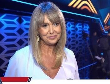 Ewa Wachowicz w stroju wspinaczkowym na tle górskiego krajobrazu, symbolizującym jej pasję do wspinaczki i zdobywania szczytów.
