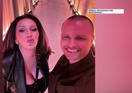 Marcin Hakiel uśmiechnięty, otoczony dziećmi, w ciepłym, naturalnym otoczeniu, symbolizujący jego życie rodzinne i rolę instruktora tańca.