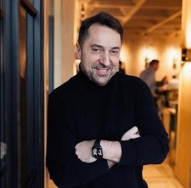 Marcin Miller, wokalista zespołu Boys, uśmiecha się do publiczności podczas koncertu, trzymając mikrofon.