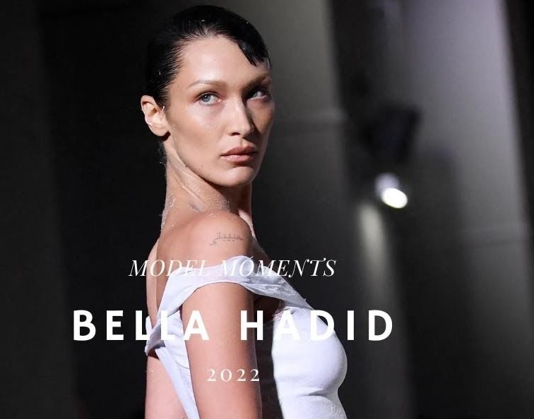 Bella Hadid na wybiegu podczas pokazu mody, prezentująca awangardową stylizację w dynamicznej pozie, oddającej energię wydarzenia.